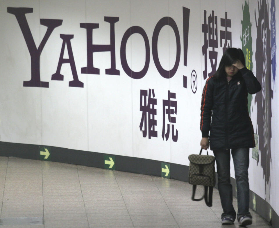 FILE - A woman walks past a Yahoo billboard in a Beijing subway in this March 17, 2006. Yahoo Inc. on Tuesday, Nov. 2, 2021 said it plans to pull out of China, citing an "increasingly challenging business and legal environment." (AP Photo, File)