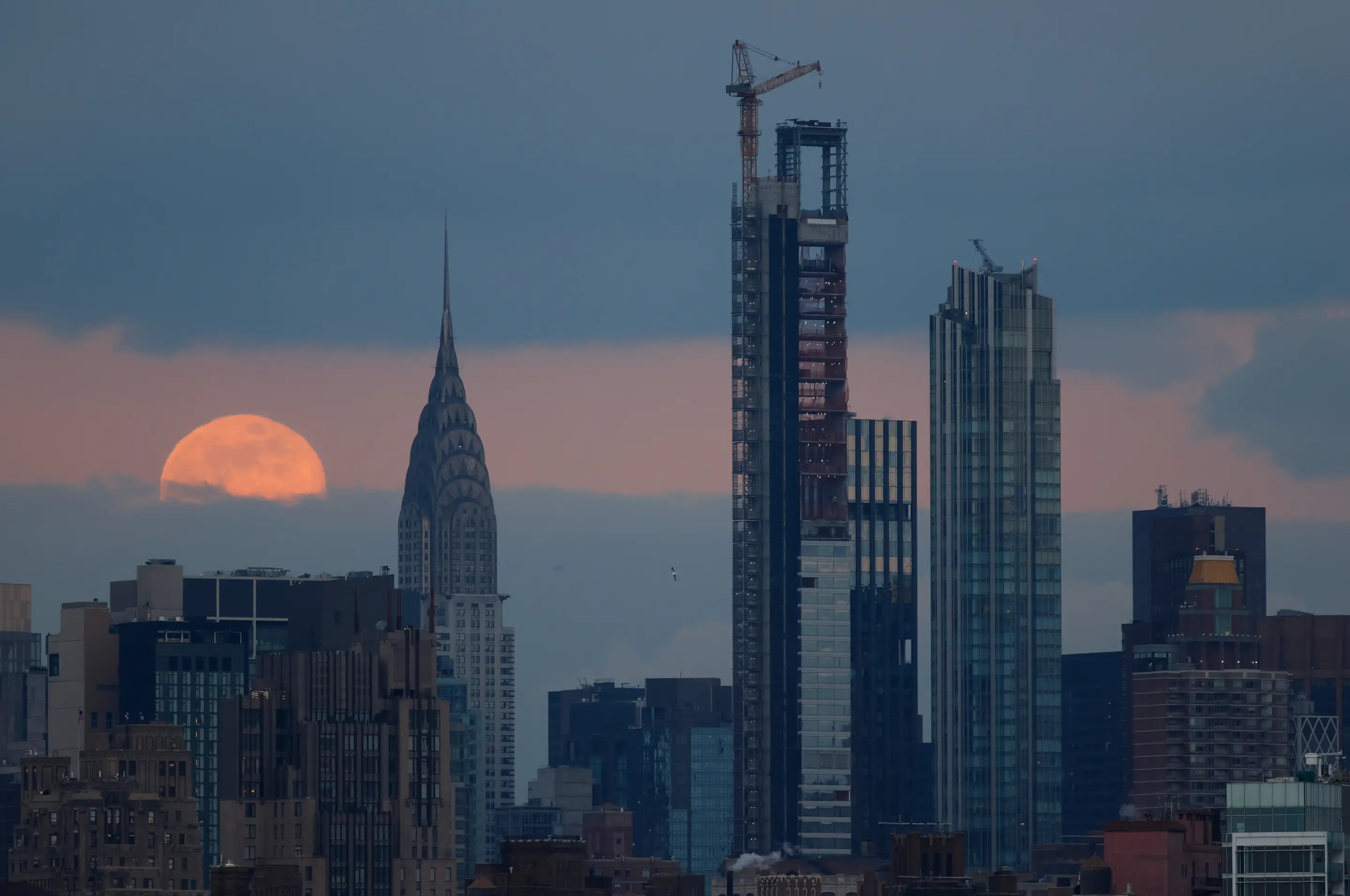 JERSEY CITY, NJ - 13 DE ENERO: La Luna llena del Lobo se alza detrás del edificio Chrysler en la ciudad de Nueva York el 13 de enero de 2025, vista desde Jersey City, Nueva Jersey. (Foto de Gary Hershorn/Getty Images)