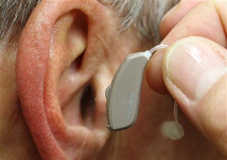 An employee of GN, the world's fourth largest maker of hearing aids, demonstrates the use of ReSound LiNX in Vienna November 22, 2013. REUTERS/Heinz-Peter Bader