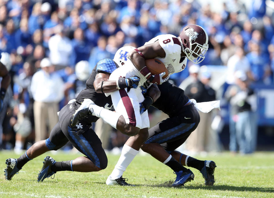 Chris Smith #8 of the Mississippi State Bulldogs runs with the ball while defended by Mikie Benton #31 and Martavius Neloms #1 of the Kentucky Wildcats during the SEC game at Commonwealth Stadium on October 6, 2012 in Lexington, Kentucky. (Photo by Andy Lyons/Getty Images);