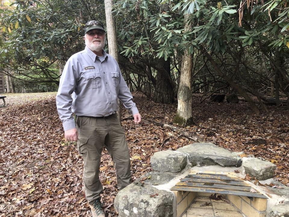 National Park Service maintenance mechanic John Coffelt is shown Wednesday, Oct. 27, 2021, standing over one of the fire pits he helped restore at a visitor center in Grandview, W.Va. Under legislation passed by Congress in 2020, some of America's most spectacular natural settings are getting a makeover. (AP Photo/John Raby)