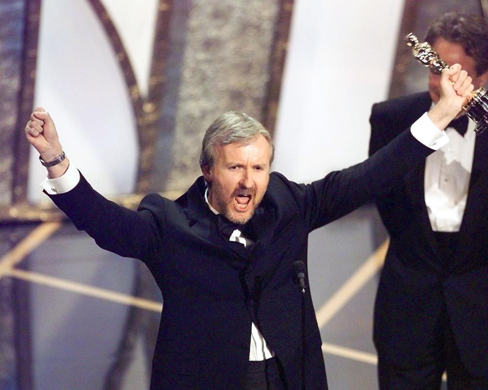 Director James Cameron raises his Oscar after winning in the Best Director Category during the 70th Academy Awards at Shrine Auditorium 23 March. Cameron won for his movie 