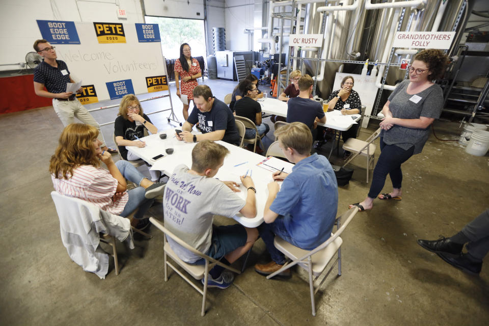 Supporters for Democratic presidential candidate Pete Buttigieg meet at a local brewery for a "relational phone bank", Thursday, Aug. 29, 2019, in West Des Moines, Iowa. The group worked their smartphones calling and texting friends to test their interest in the candidate. Buttigieg is well behind his better known rivals in Iowa who have spent months building a deep organizational structure in the state that marks the first test for the Democratic presidential nomination. But thanks to his campaign taking in nearly $25 million in contributions in the last quarter, money that he is using to help create an army of peer-to-peer foot soldiers, Buttigieg is rapidly trying to catch up. (AP Photo/Charlie Neibergall)