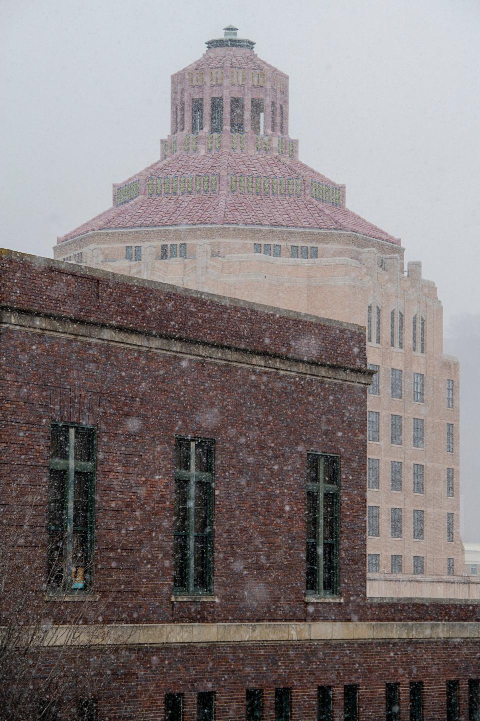 Snow falls on Asheville City Hall, January 19, 2024.