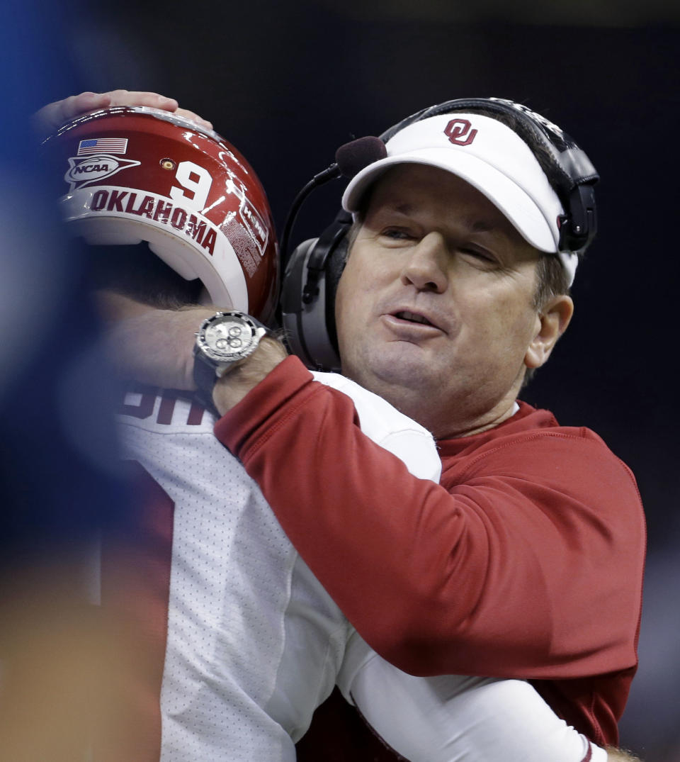 Oklahoma coach Bob Stoops hugs quarterback Trevor Knight during the first half of the Sugar Bowl NCAA college football game against Alabama, Thursday, Jan. 2, 2014, in New Orleans. (AP Photo/Rusty Costanza)