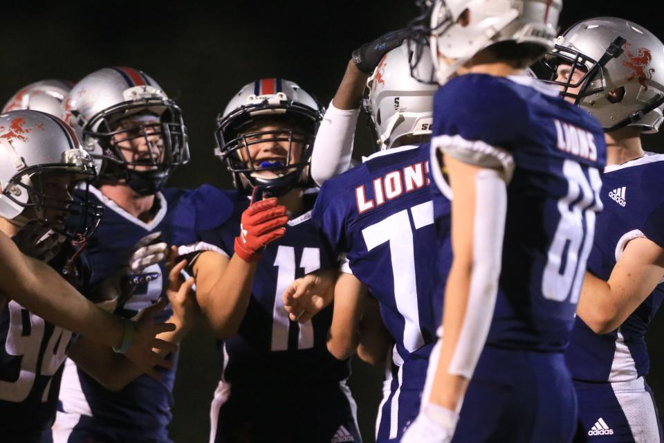 Cair Paravel's offensive line celebrates on the sidelines after completing a touchdown and two-point conversion against Maranatha on Friday night.
(Photo: Evert Nelson/The Capital-Journal)