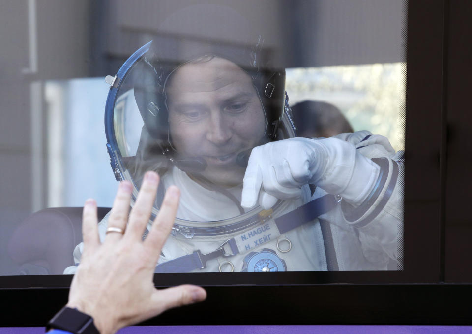 U.S. astronaut Nick Hague, member of the main crew to the International Space Station (ISS), waves to his relatives from a bus prior to the launch of Soyuz-FG rocket at the Russian leased Baikonur cosmodrome, Kazakhstan, Thursday, Oct. 11, 2018. (AP Photo/Dmitri Lovetsky, Pool)