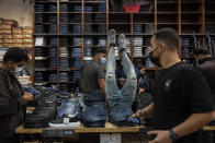 Consumers shop at a clothing store at a shopping center in the city of Beersheba, southern Israel, Sunday, Feb. 21, 2021. Israel lifted many of its coronavirus restrictions and started reopening its economy Sunday as the country's vaccination drive and third nationwide lockdown have started to bring down infections. (AP Photo/Tsafrir Abayov)