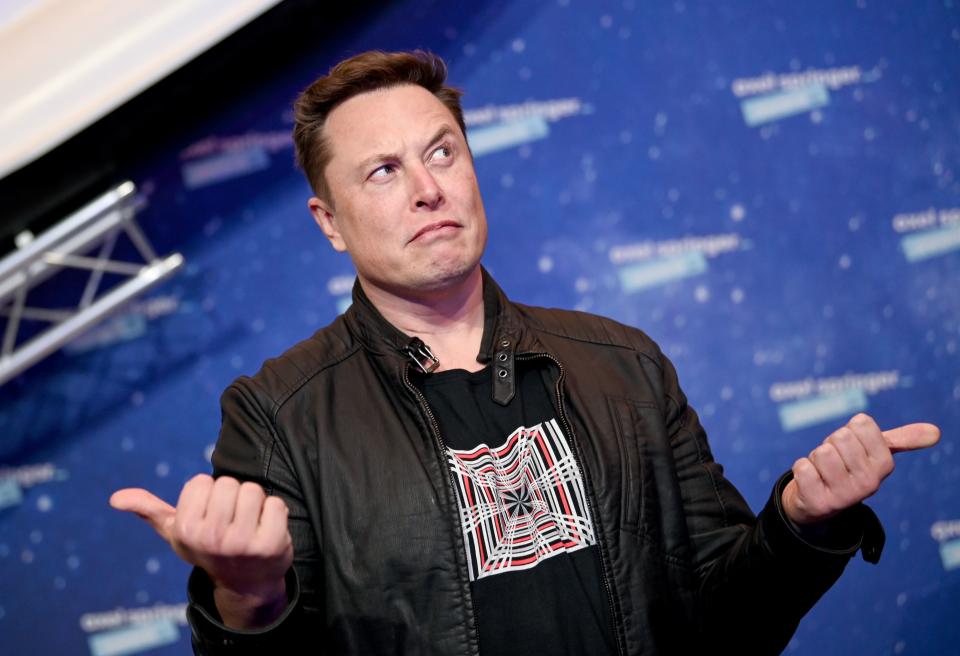 SpaceX owner and Tesla CEO Elon Musk (R) gestures as he arrives on the red carpet for the Axel Springer Awards ceremony, in Berlin, on December 1, 2020. (Photo by Britta Pedersen / POOL / AFP) (Photo by BRITTA PEDERSEN/POOL/AFP via Getty Images)