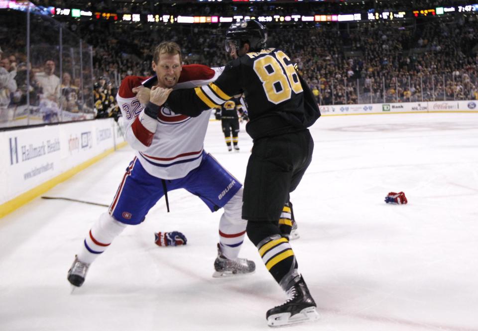 Boston Bruins defenseman Kevan Miller (86) fights with Montreal Canadiens left wing Travis Moen (32) during the first period of an NHL hockey game, Monday, March 24, 2014, in Boston. (AP Photo/Charles Krupa)