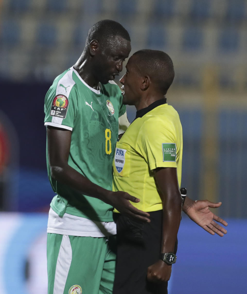 Senegal's Cheikhou Kouyate talks to referee during the African Cup of Nations semifinal soccer match between Senegal and Tunisia in 30 June stadium in Cairo, Egypt, Sunday, July 14, 2019. (AP Photo/Hassan Ammar)