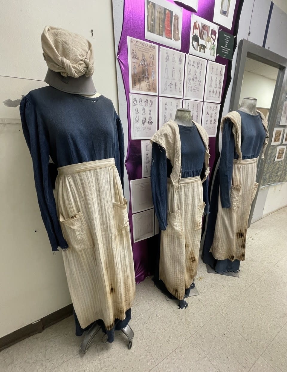 Three muslin dresses with aprons lined up