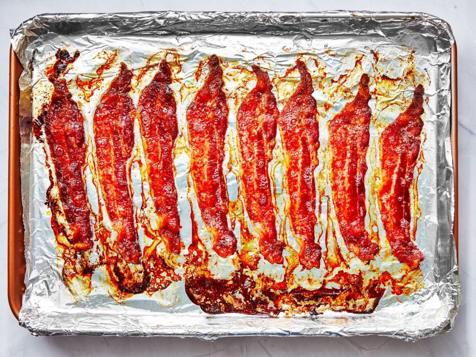 cooked bacon on a pan lined with aluminum foil