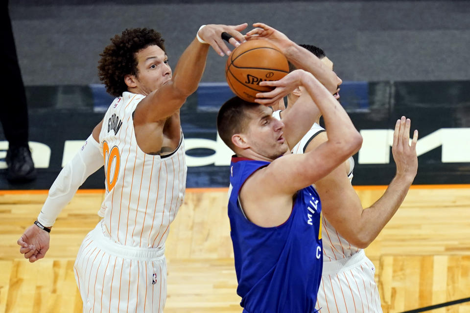 Orlando Magic forward Aaron Gordon, left, comes from behind to block as shot by Denver Nuggets center Nikola Jokic during the first half of an NBA basketball game, Tuesday, March 23, 2021, in Orlando, Fla. (AP Photo/John Raoux)