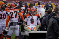 Cincinnati Bengals quarterback Joe Burrow (9) is consoled by teammates as he is carted off the field during the second half of an NFL football game against the Washington Football Team, Sunday, Nov. 22, 2020, in Landover. Burrow was carted off the field with a left knee injury. (AP Photo/Susan Walsh)