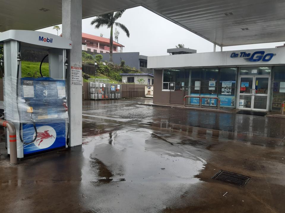 A Mobil gas station shutters its convenience store and gas pumps in preparation for cyclone Yasa in Suva, Fiji, Thursday, Dec. 17, 2020. Fiji was urging people near the coast to move to higher ground Thursday ahead of a nationwide curfew as the island nation prepared for a major cyclone to hit.(AP Photo/Aileen Torres-Bennett)