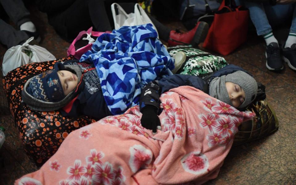 Children sleeping on the floor at Lviv central train station in Western Ukraine - DANIEL LEAL/AFP
