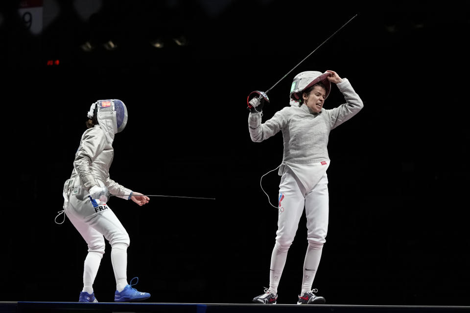 Olga Nikita of the Russian Olympic Committee, right, celebrates defeating Cecilia Berder of France and won with her teammates the women's Sabre team final competition at the 2020 Summer Olympics, Saturday, July 31, 2021, in Chiba, Japan. (AP Photo/Hassan Ammar)