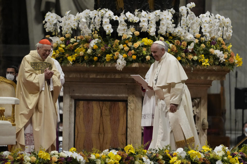 Pope Francis, right, walks past Cardinal Giovanni Battista Re as he presides over a Easter vigil ceremony in St. Peter's Basilica at the Vatican, Saturday, April 16, 2022. (AP Photo/Alessandra Tarantino)