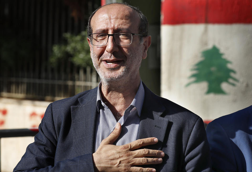 Hezbollah legal representative Ibrahim Mussawi gestures as he arrives to speak with journalists outside the Justice Palace in Beirut, Lebanon, Friday, Dec. 4, 2020. Lebanese Hezbollah said on Friday it is suing a former Christian lawmaker and a website affiliated with a Christian party for defamation after they accused the militant group of the massive explosion at the Beirut Port this summer. Hezbollah has denied any role in the Aug. 4 explosion that devastated Beirut and was caused by the detonation of nearly 3,000 of tons of explosive chemicals stored there for six years. (AP Photo/Hussein Malla)