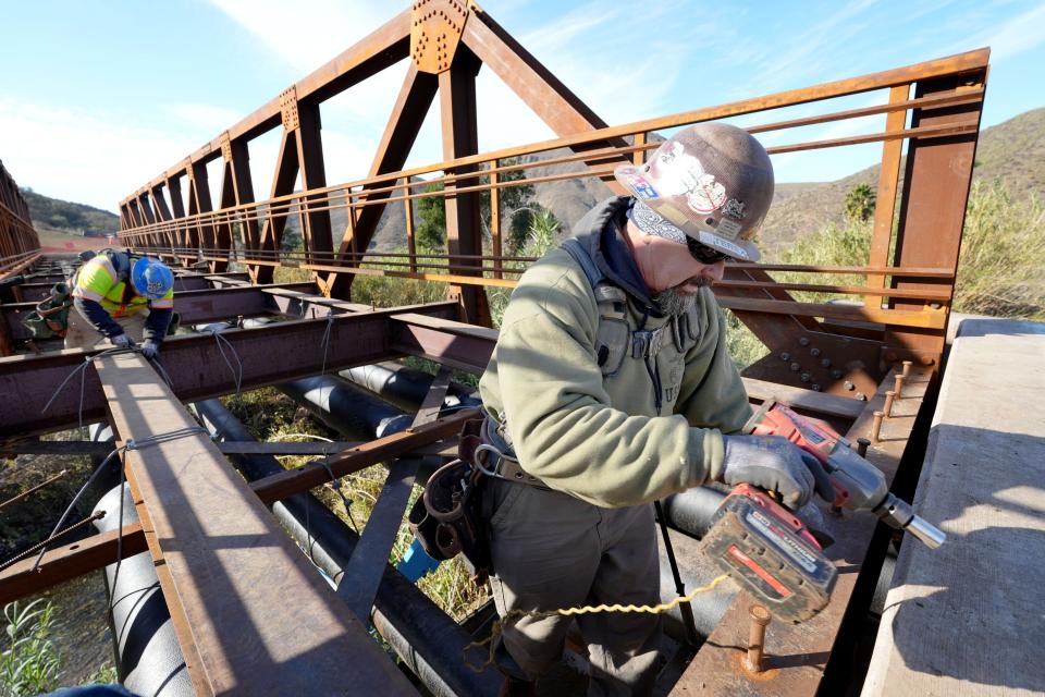 Xavier Servin, left, of Santa Paula and Joe Scholle of Oxnard work on the Conejo Canyons Bridge project near the Hill Canyon Treatment Plant in Thousand Oaks on Dec. 28. The new bridge will connect existing trails on either side of Arroyo Conejo creek.