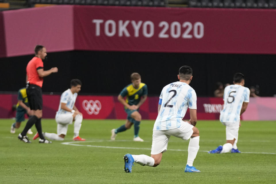 Players of Argentina and Australia kneel prior to their men's soccer match at the 2020 Summer Olympics, Thursday, July 22, 2021, in Sapporo, Japan. (AP Photo/SIlvia Izquierdo)