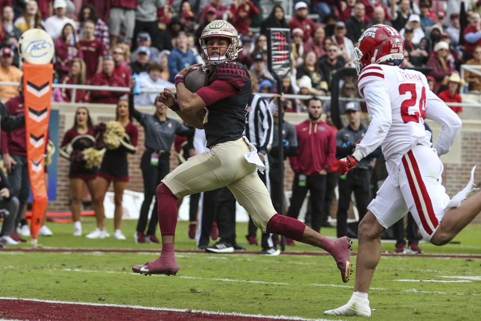 Florida State quarterback Jordan Travis (13) runs the ball for a touchdown during the first half of an NCAA college football game against Louisiana on Saturday, Nov. 19, 2022, in Tallahassee, Fla. (AP Photo/Gary McCullough)