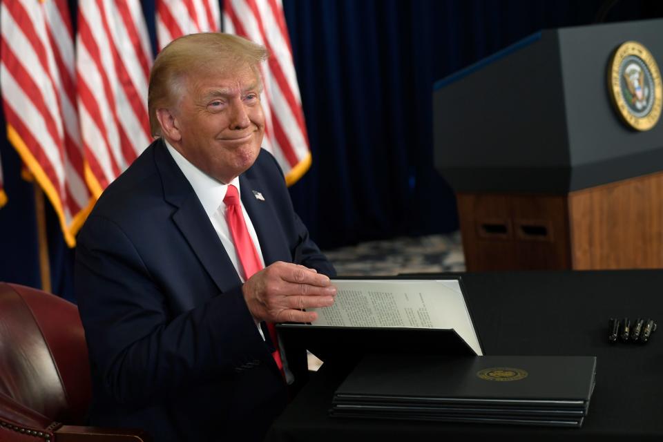 President Donald Trump smiles as he is about to sign four executive actions during a news conference at the Trump National Golf Club in Bedminster, N.J., Saturday, Aug. 8, 2020. (AP Photo/Susan Walsh)