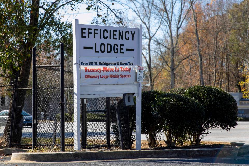 An Efficiency Lodge road sign saying "Free Wi-Fi, Refrigerator & Stove Top; Vacancy-Move In Today; Efficiency Lodge Weekly Specials."
