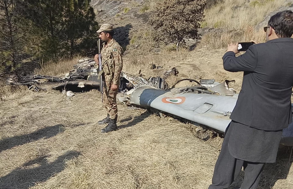 A Pakistani soldier stands guard near the wreckage of an Indian plane shot down by the Pakistan military on Wednesday, in Hurran, near the Line of Control in Pakistani Kashmir, Thursday, Feb. 28, 2019. Prime Minister Imran Khan said Pakistan will release the captured Indian fighter pilot as a "peace gesture" toward India. Khan made this announcement on Thursday while addressing lawmakers in both chambers of Parliament, convened to discuss the latest situation amid rising tensions with the nuclear-armed neighbor over the disputed territory of Kashmir. (AP Photo/Abdul Razzaq)