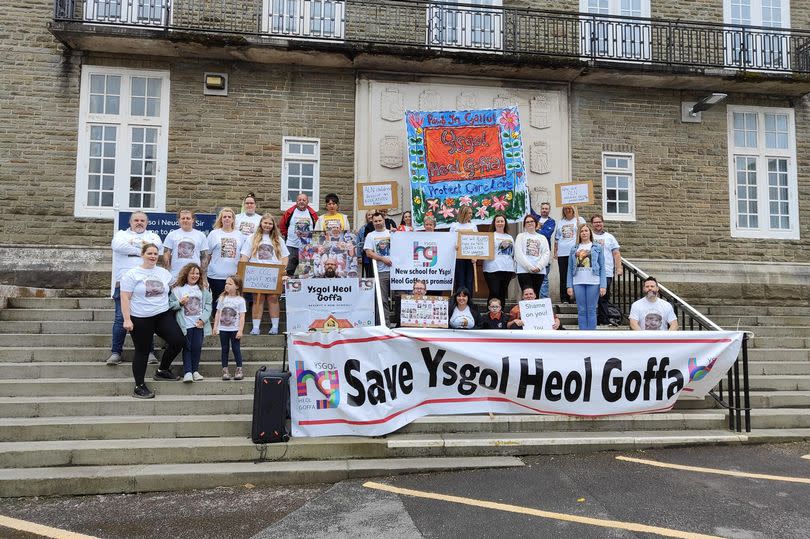 Protest outside public building with people holding banners and placards