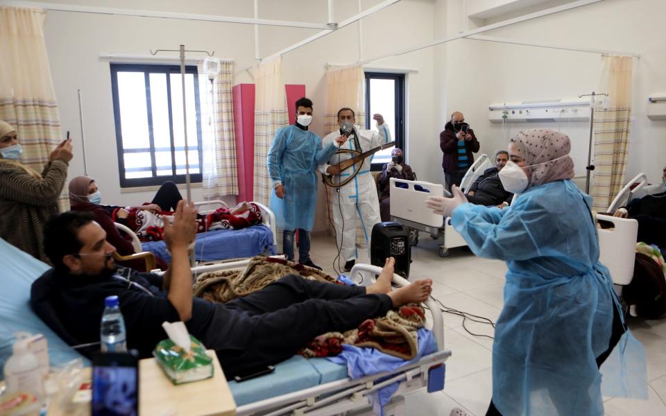  A Palestinian singer performs for Covid-19 patients at a hospital in the West Bank city of Hebron - Shutterstock