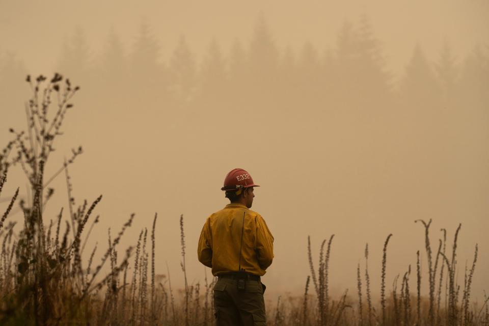 A firefighter surveys a field near the Riverside Fire on September 13, 2020 in Glen Avon, Oregon.