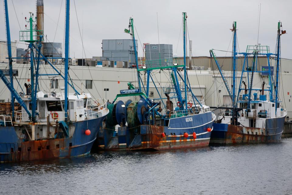 Boats are docked in front of the Blue Harvest Fisheries plant on Herman Melville Boulevard in New Bedford.