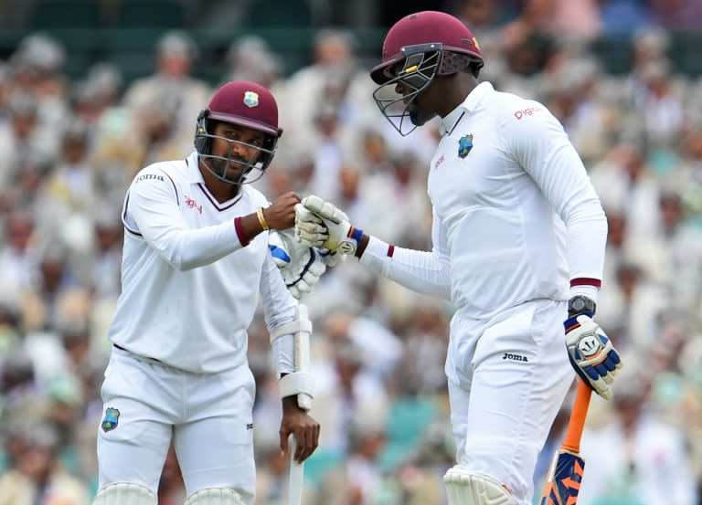 West Indies batsmen Denesh Ramdin (L) and Carlos Brathwaite (R) bump fists after taking more runs from the Australian bowling on the second day of the third Test in Sydney on January 4, 2016