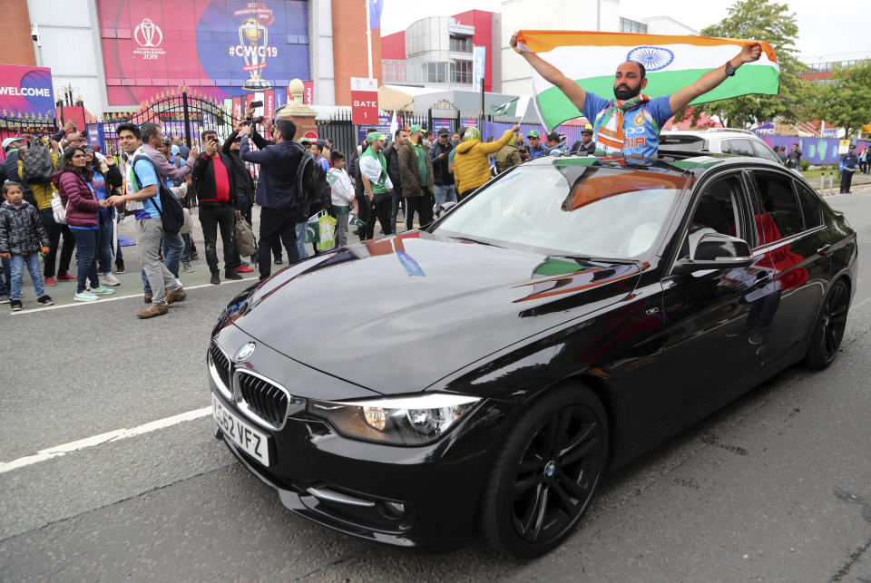 An Indian fan displays a flag as he arrives with others before the start of the Cricket World Cup match between India and Pakistan at Old Trafford in Manchester, England, Sunday, June 16, 2019. (AP Photo/Aijaz Rahi)