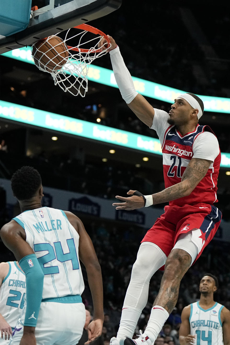 Washington Wizards center Daniel Gafford scores as Charlotte Hornets forward Brandon Miller looks on during the first half of an NBA basketball game on Wednesday, Nov. 22, 2023, in Charlotte, N.C. (AP Photo/Chris Carlson)