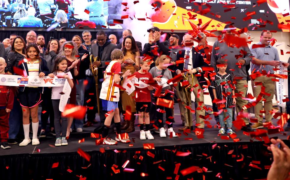 People celebrate after the ribbon cutting during the grand opening of the Young Family Athletic Center in Norman, Okla., Monday, Feb. 19, 2024.