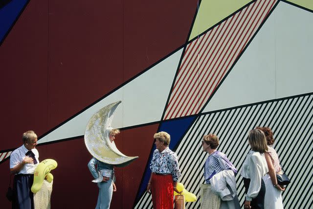 <p>Â©Estate of Roy Lichtenstein, 1987, all rights reserved.Â© Sabina Sarnitz/Courtesy of Luna Luna, LLC</p> Performer in front of Roy Lichtensteinâ€™s Luna Luna Pavilion. Luna Luna, Hamburg, Germany, 1987