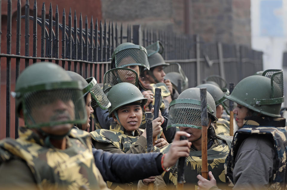 Indian police personnel stand guard at a barricade as Indians protest against the Citizenship Amendment Act in New Delhi, India, Friday, Dec. 20, 2019. Police banned public gatherings in parts of the Indian capital and other cities for a third day Friday and cut internet services to try to stop growing protests against a new citizenship law that have left eight people dead and more than 4,000 others detained. (AP Photo/Altaf Qadri)