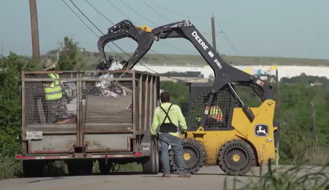 City crews clean up illegally dumped trash along Lindell Lane in East Austin (KXAN Photo/Richie Bowes)