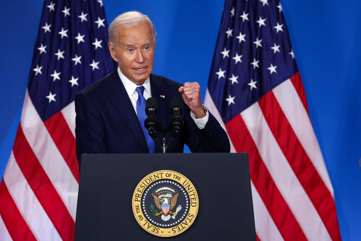 President Biden stands at a podium emblazoned with the presidential seal.