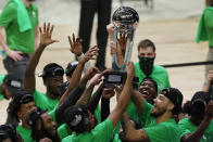 North Texas players celebrate with the trophy after the championship game against Western Kentucky in the NCAA Conference USA men's basketball tournament Saturday, March 13, 2021, in Frisco, Texas. North Texas won 61-57 in overtime. (AP Photo/Tony Gutierrez)