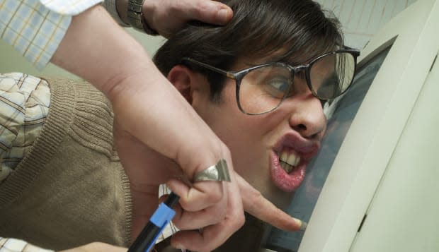 Manager pushing office worker's face against computer screen