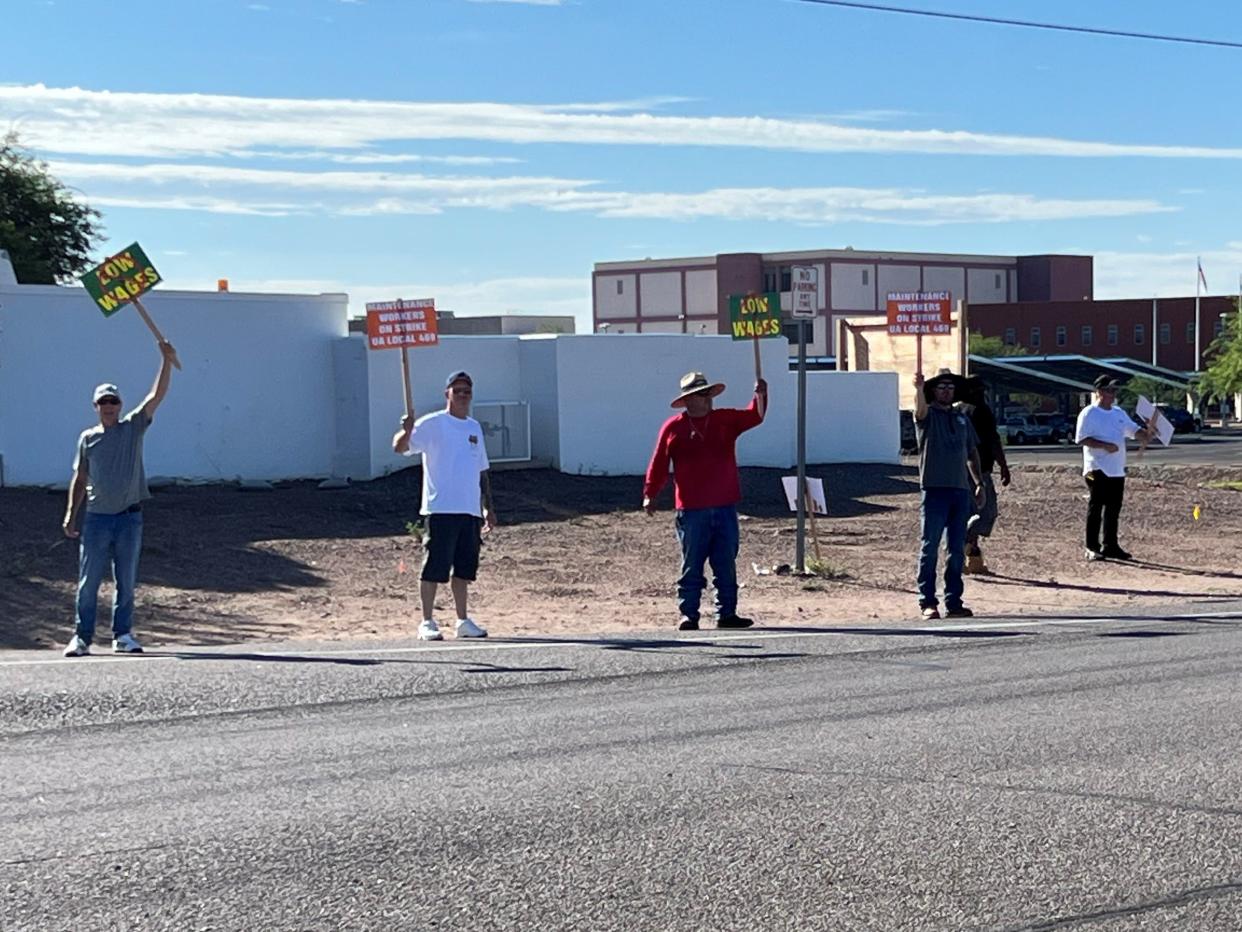 Unionized maintenance workers stand on a picket line outside a private prison run by CoreCivic in Florence, AZ