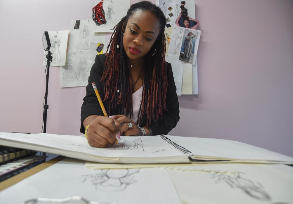 In between sales, fashion designer Kallee Jackson works on sketching new ideas for dresses while in her shop on Friday, Nov. 10, 2023, in Port St. Lucie.