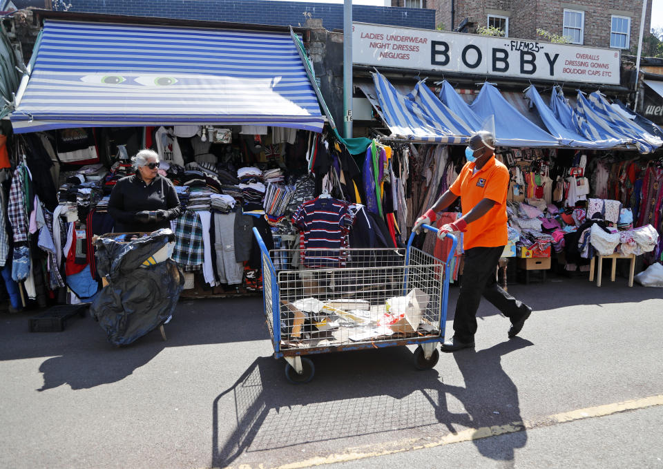 Shop owners prepare to reopen their stores at Shepherd's bush market after the COVID-19 lockdown in London, Monday, June 1, 2020. The British government has lifted some lockdown restrictions to restart social life and activate the economy while still endeavouring to limit the spread of the highly contagious COVID-19 coronavirus.(AP Photo/Frank Augstein)