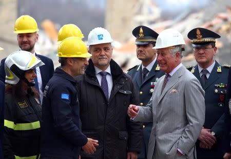 Britain's Prince Charles speaks with an Italy's Civil Protection agency member during his visit to the town of Amatrice, which was levelled after an earthquake last year, in central Italy April 2, 2017. REUTERS/Alessandro Bianchi