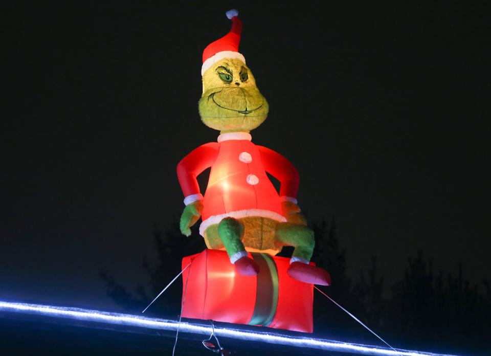 The Grinch looks down from the Red Lion Road home of Nino Mallari and Gloria Rivera, just up the street from the Fauchers' well known over-the-top holiday light display.