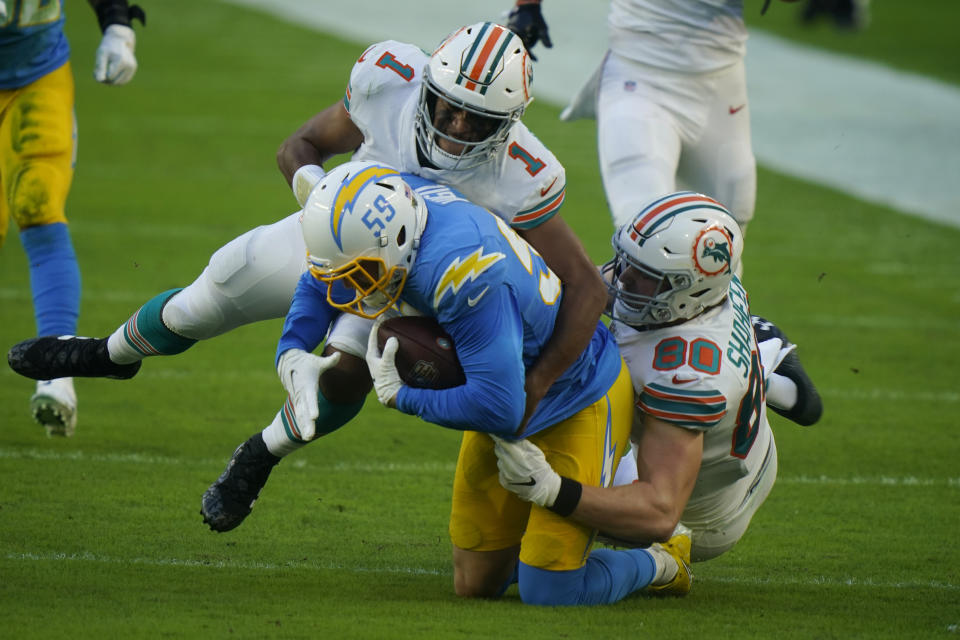 Miami Dolphins quarterback Tua Tagovailoa (1) and tight end Adam Shaheen (80) tackle Los Angeles Chargers outside linebacker Nick Vigil (59) after the Dolphins fumbled the ball, during the first half of an NFL football game, Sunday, Nov. 15, 2020, in Miami Gardens, Fla. (AP Photo/Lynne Sladky)